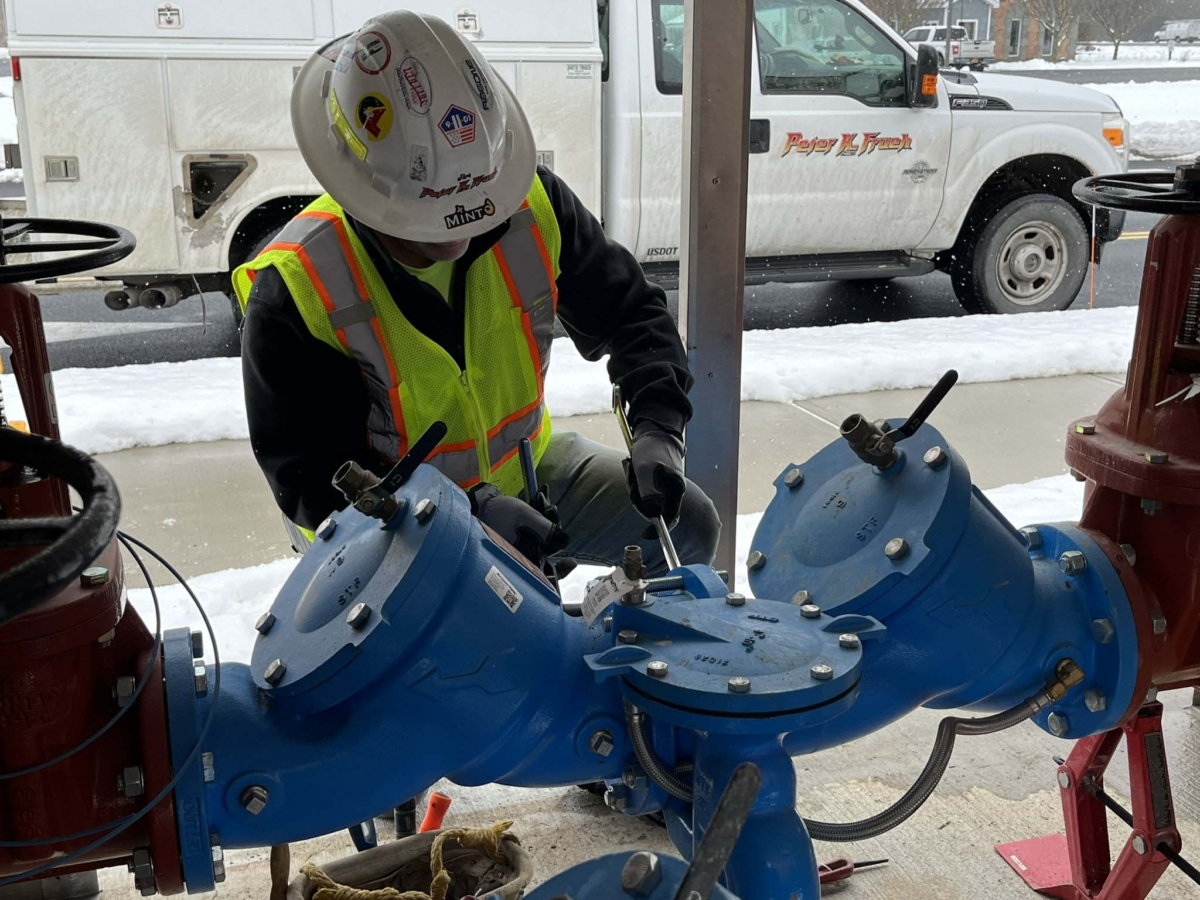 Construction worker servicing a utility pipe