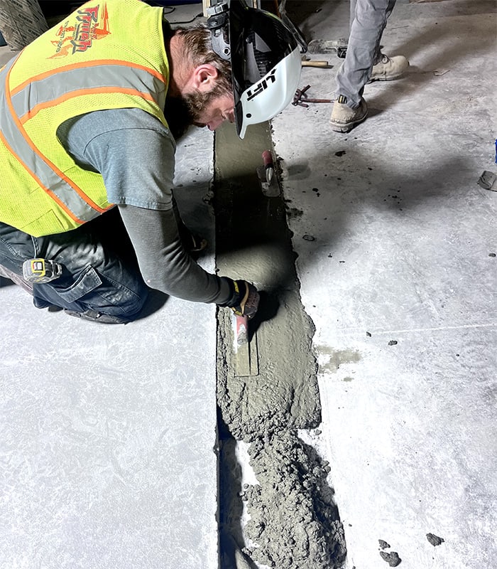PKFI worker laying concrete into a gap