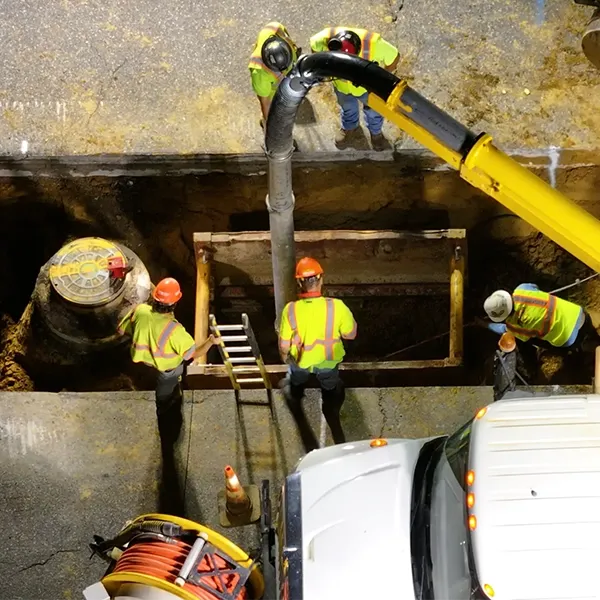 Workers are working at a construction site with heavy machinery and equipment.