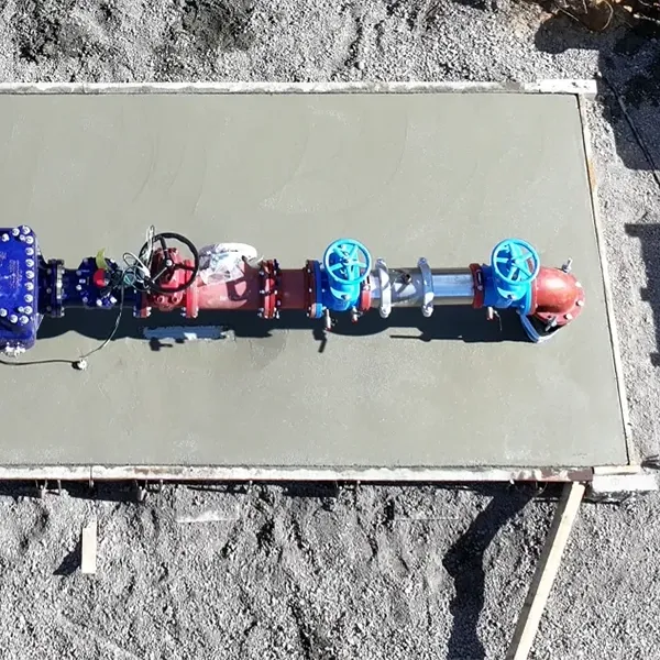 A concrete slab with various colored valves and pipes on it.
