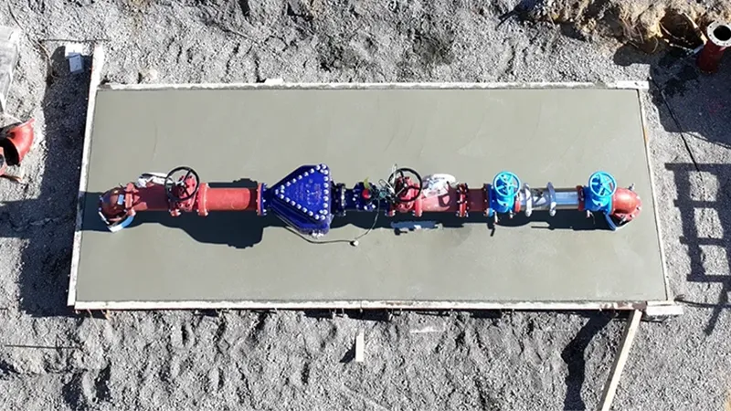 A concrete slab with various colored valves and pipes on it.