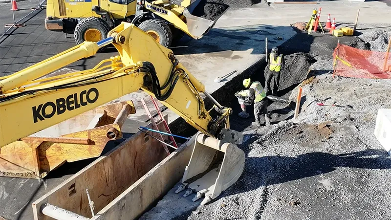 A construction site with a worker and machinery is shown.
